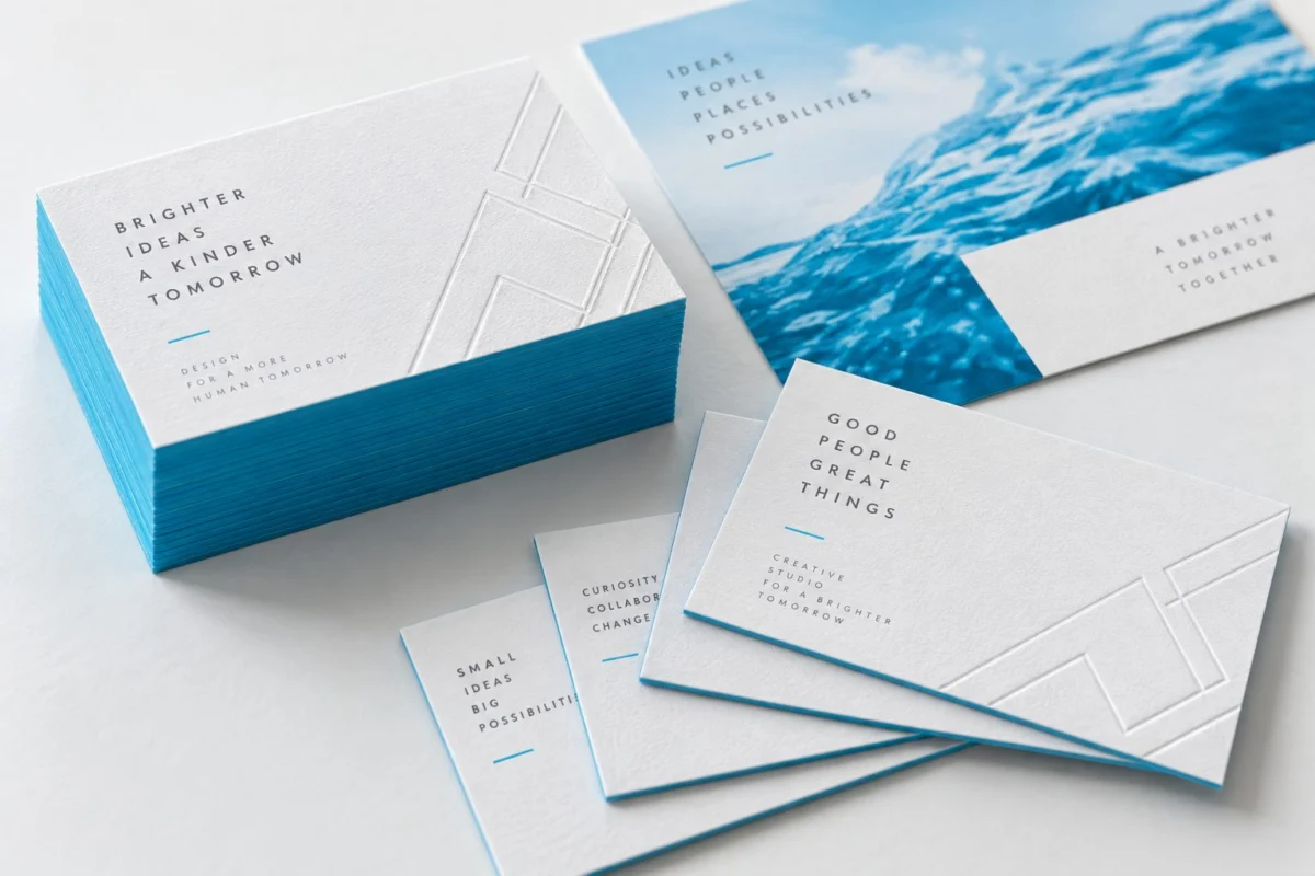 Tarjetas blancas con textura y bordes cian junto a una postal promocional